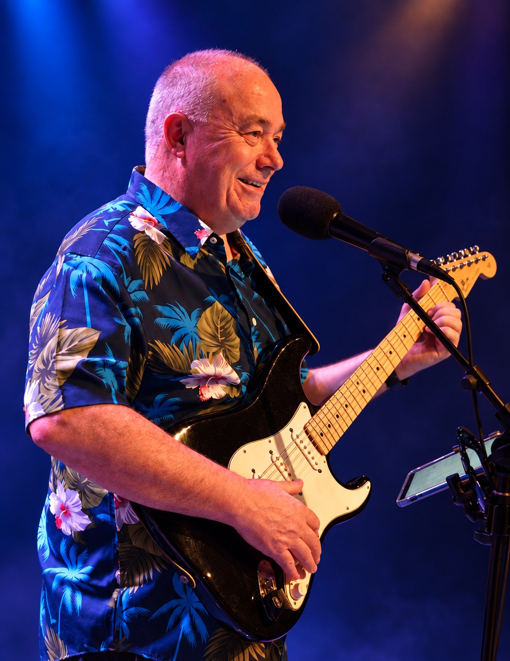 Sunday Service guitarist and vocalist smiling during a live performance.